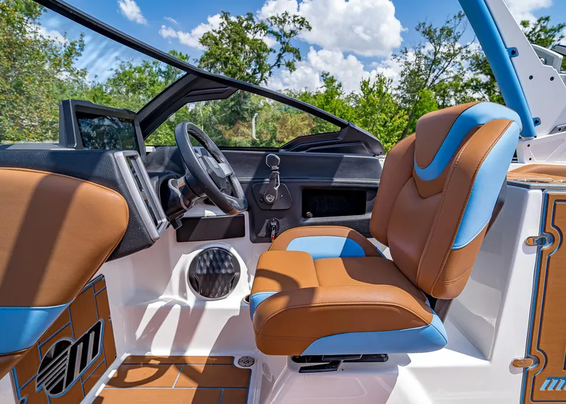 Slide: The Image of 2024 Malibu Wakesetter 24 MXZ interior with brown and blue seating, steering wheel, and dashboard. - 18