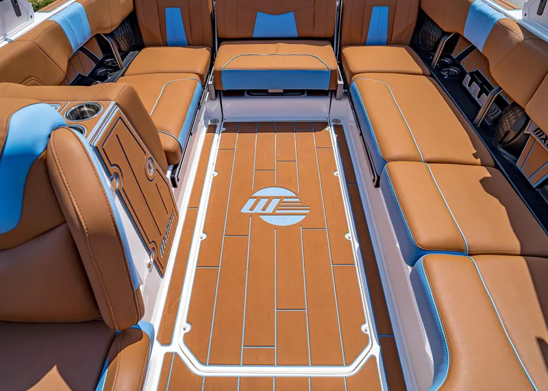 Slide: The Image of 2024 Malibu Wakesetter 24 MXZ interior with tan and blue seating, spacious layout. - 27