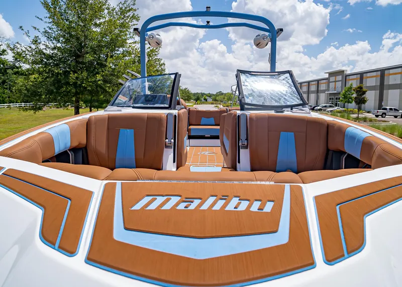 Slide: The Image of 2024 Malibu Wakesetter 24 MXZ boat interior with brown and blue seating. - 34