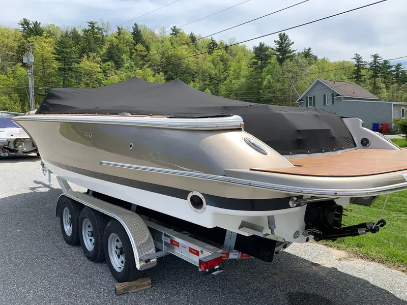 Slide: The Image of 2012 Chris-Craft Launch 28 boat on trailer, covered, parked outdoors. - 10
