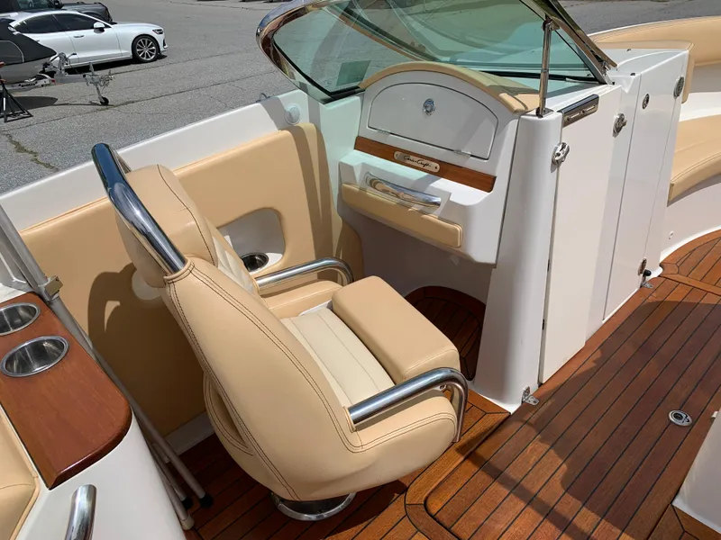 Slide: The Image of 2012 Chris-Craft Launch 28 boat interior with beige seating and wooden flooring. - 18