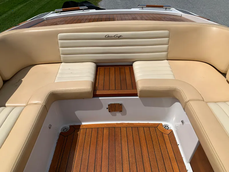 Slide: The Image of 2012 Chris-Craft Launch 28 boat interior with beige seating and wooden flooring. - 22