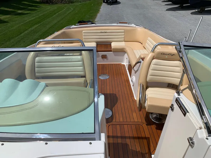 Slide: The Image of 2012 Chris-Craft Launch 28 boat interior with beige seating and wooden deck. - 29