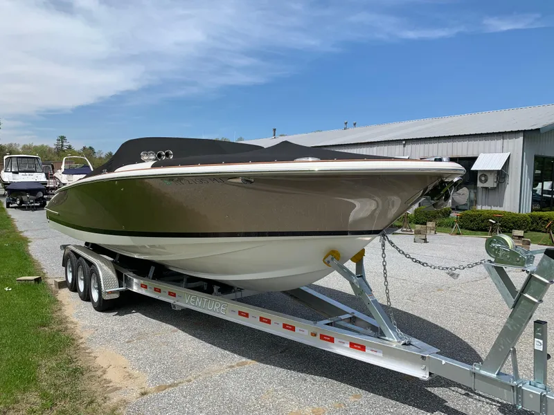 Slide: The Image of 2012 Chris-Craft Launch 28 boat on trailer, parked outdoors near a building. - 7