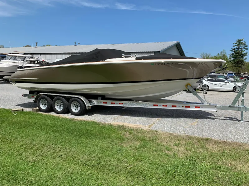 Slide: The Image of 2012 Chris-Craft Launch 28 boat on a trailer, parked outdoors on a sunny day. - 8