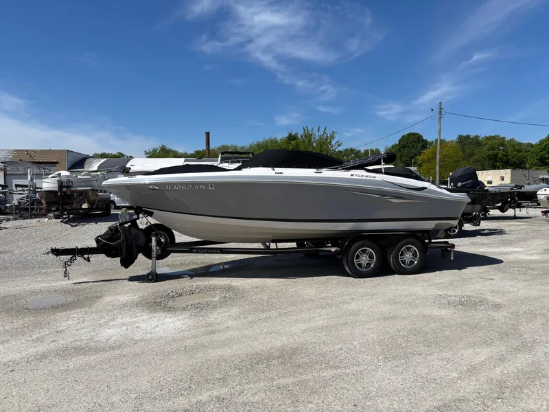 Slide: The Image of 2012 Four Winns H220 boat on a trailer in a sunny outdoor setting. - 1
