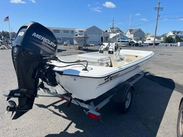 Slide: The Image of 2018 Mako Pro Skiff 17 CC boat with Mercury engine on trailer in marina setting. - 3