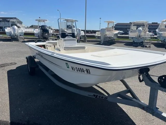 Slide: The Image of 2018 Mako Pro Skiff 17 CC boat on trailer in marina setting. - 4