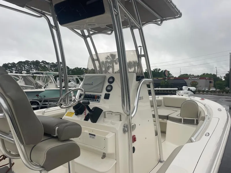 Slide: The Image of 2021 Key West 239 FS boat interior with steering console and seating under cloudy skies. - 3