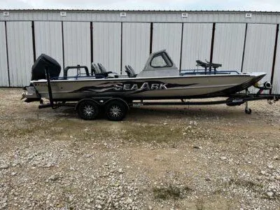 The Image of 2025 SeaArk ProCat 240 boat on trailer, parked outdoors near storage units. - 0