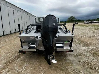 Slide: The Image of 2025 SeaArk ProCat 240 boat with powerful outboard motor, parked on gravel near a building. - 6