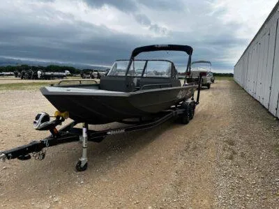 Slide: The Image of 2025 SeaArk ProCat 240 boat on trailer, parked outdoors under cloudy sky. - 3