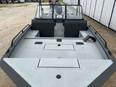 Slide: The Image of 2025 SeaArk ProCat 240 boat with spacious deck and windshield, parked outdoors. - 9