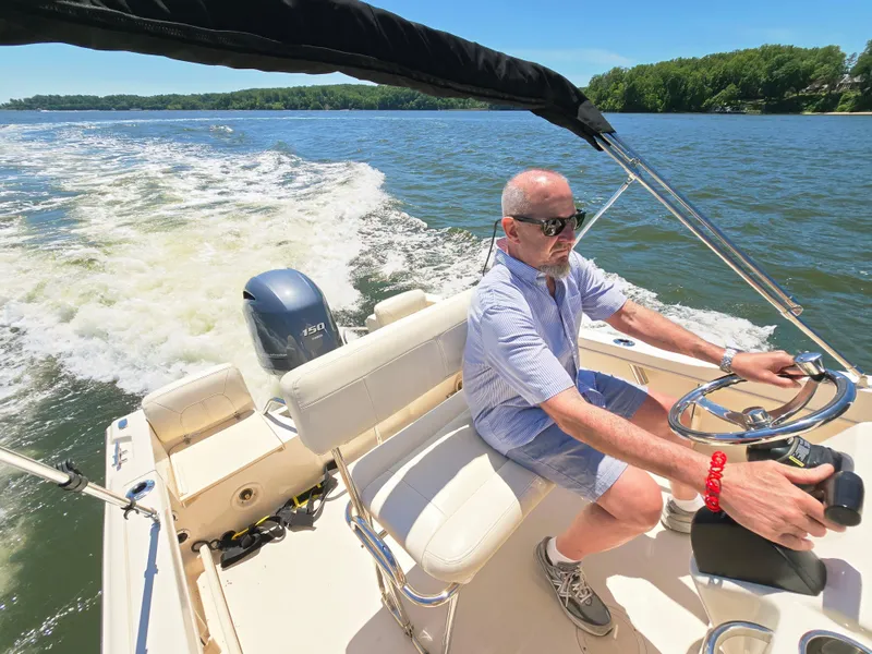 Slide: The Image of Man steering 2023 Grady-White Fisherman 180 boat on a sunny day. - 22