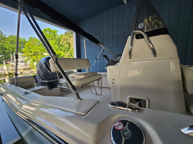 Slide: The Image of 2023 Grady-White Fisherman 180 boat interior with seating and controls, docked under a canopy. - 37