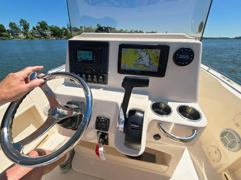 Slide: The Image of 2023 Grady-White Fisherman 180 boat console with GPS and steering wheel on a sunny day. - 8