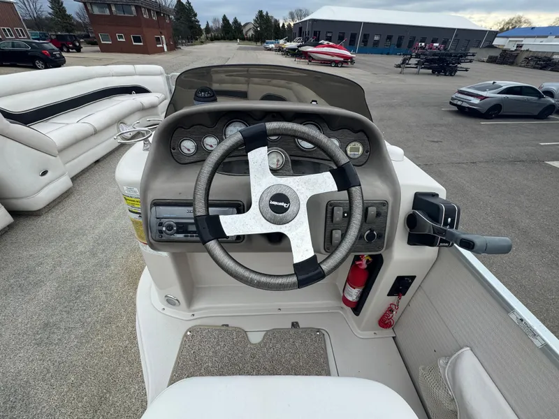 Slide: The Image of Steering console of a 2007 Premier Grand Majestic 22 pontoon boat, featuring gauges and controls. - 22