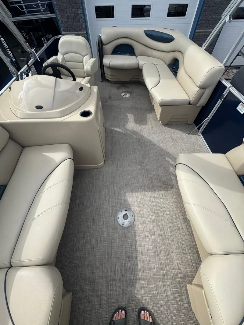 Slide: The Image of 2017 Sylvan Mirage 818 Cruiser interior with beige seating and steering console. - 3