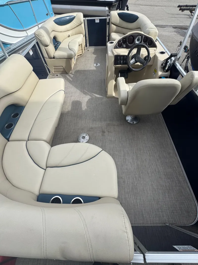 Slide: The Image of 2017 Sylvan Mirage 818 Cruiser interior with beige seating and steering console. - 6