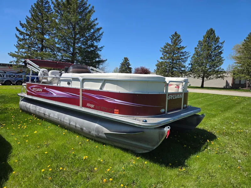 Slide: The Image of 2011 Sylvan Mirage 8520 pontoon boat on grassy lawn with trees in background. - 1