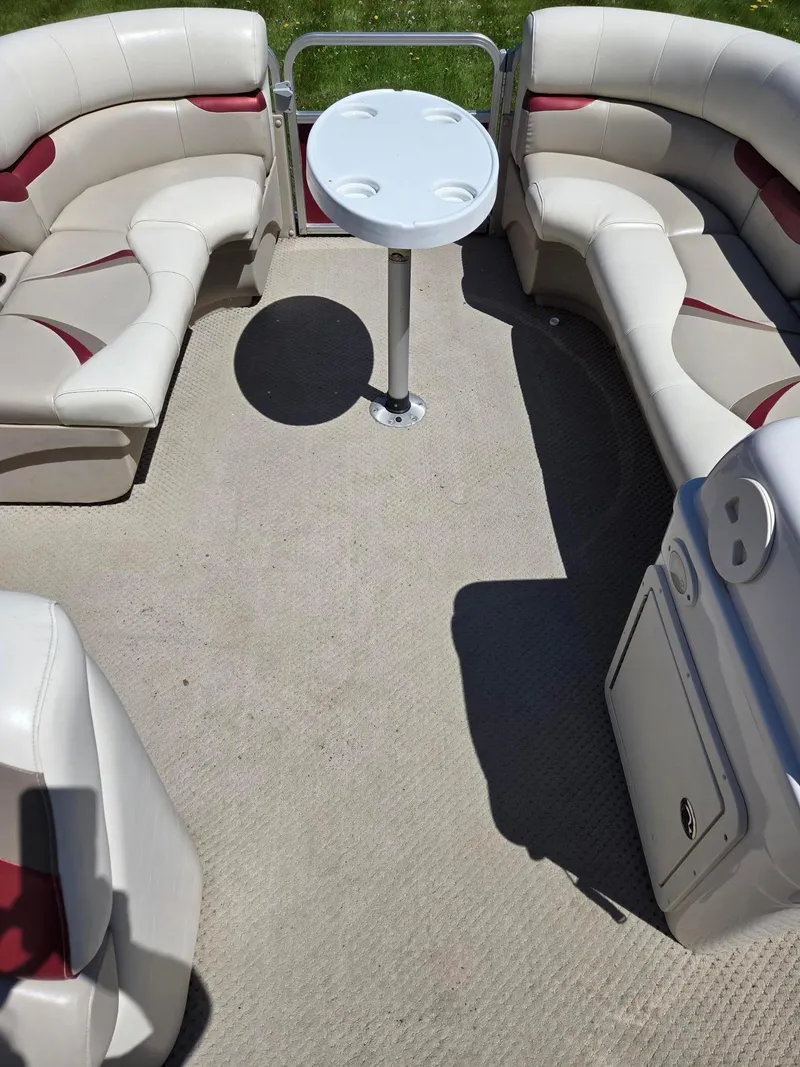 Slide: The Image of 2011 Sylvan Mirage 8520 pontoon boat interior with beige seating and round table. - 10