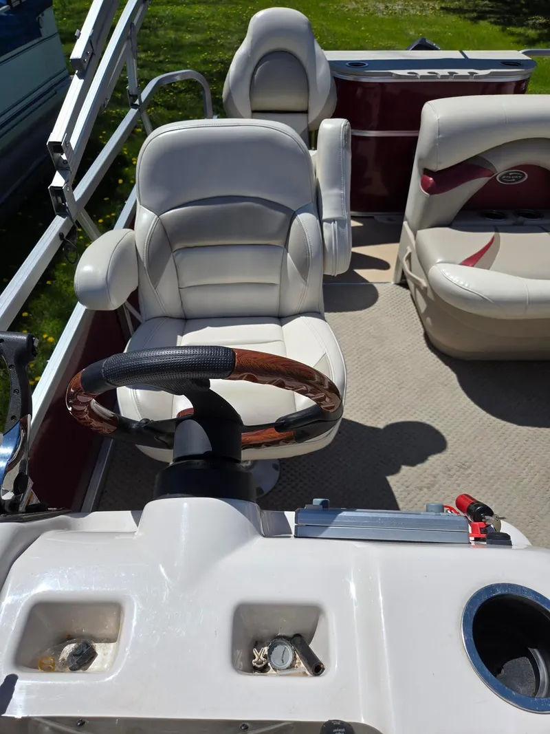 Slide: The Image of 2011 Sylvan Mirage 8520 boat interior with steering wheel and seating. - 16