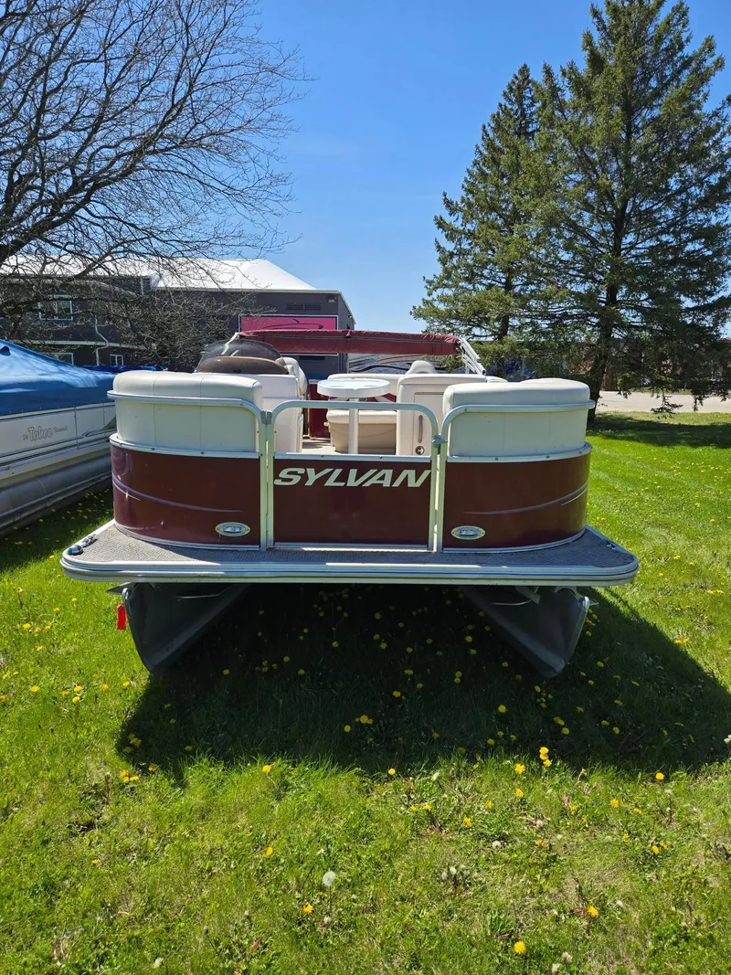 Slide: The Image of 2011 Sylvan Mirage 8520 pontoon boat on grass, sunny day, trees in background. - 2