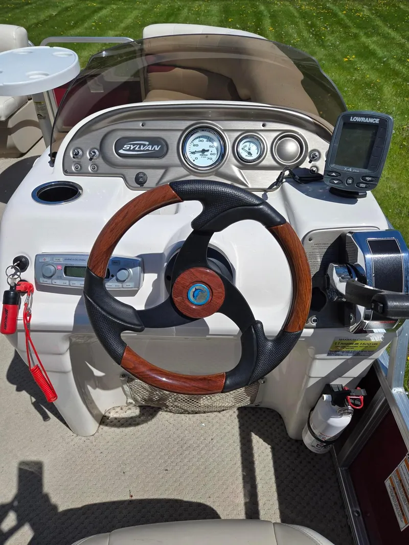 Slide: The Image of Steering console of a 2011 Sylvan Mirage 8520 boat with gauges and navigation equipment. - 8