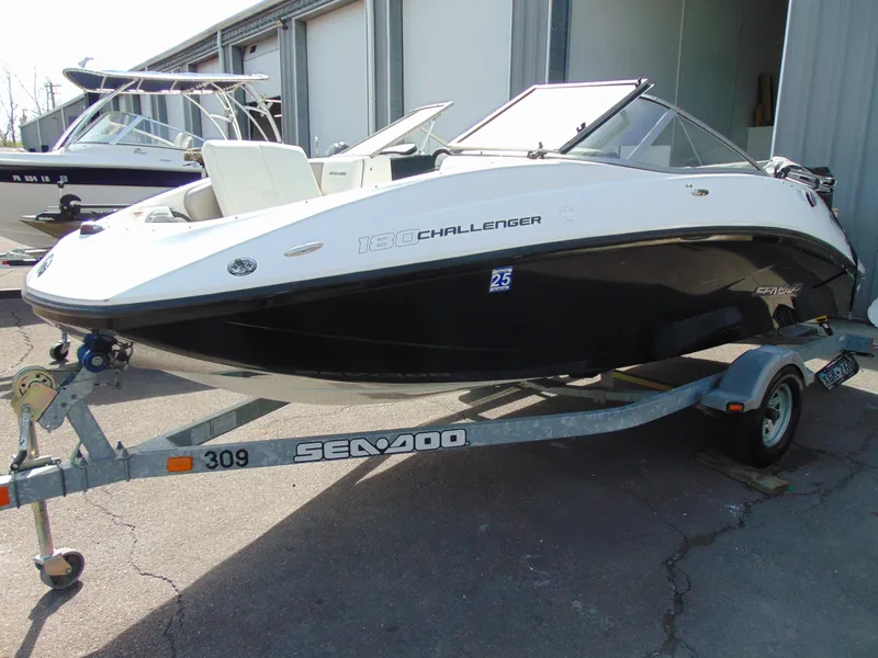 Slide: The Image of 2011 Sea-Doo 180 Challenger SE boat on trailer, parked outdoors. - 22