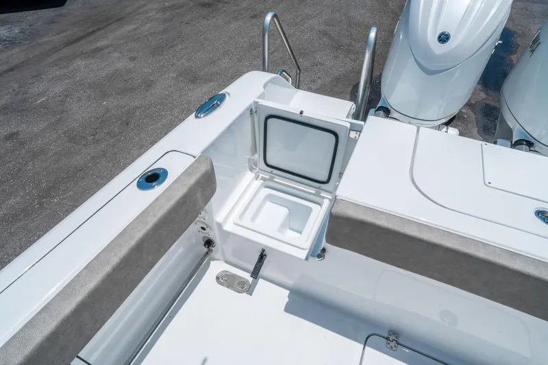 Slide: The Image of 2025 Sea Hunt Gamefish 25 boat interior with open storage compartment and twin engines. - 14