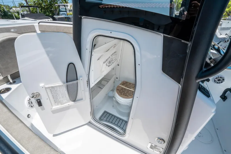 Slide: The Image of 2025 Sea Hunt Gamefish 25 boat interior with open door revealing compact marine toilet. - 23