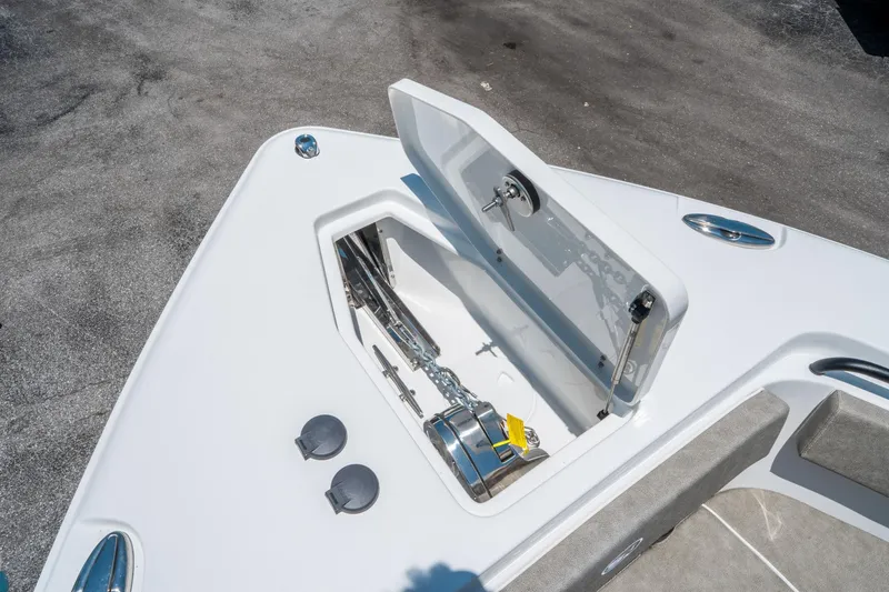 Slide: The Image of 2025 Sea Hunt Gamefish 25 anchor storage compartment with open lid, showcasing chain and winch. - 30