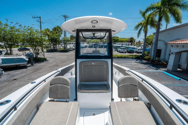Slide: The Image of 2025 Sea Hunt Gamefish 25 boat interior with seating, parked outdoors under clear blue sky. - 26