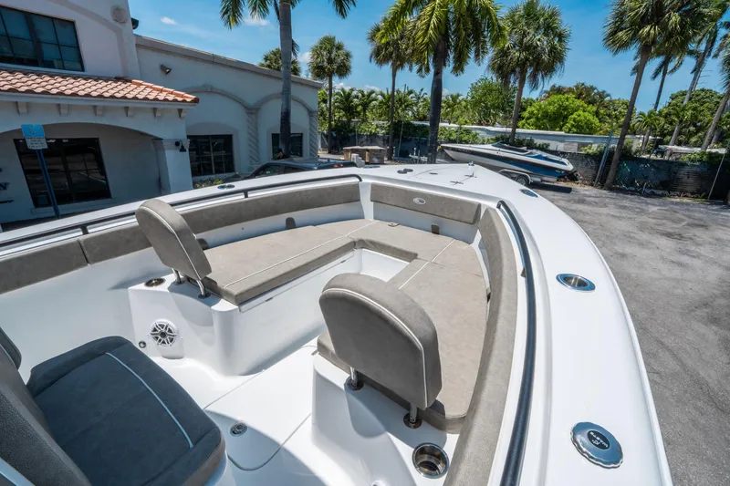 Slide: The Image of 2025 Sea Hunt Gamefish 25 boat interior with seating, docked near palm trees. - 25