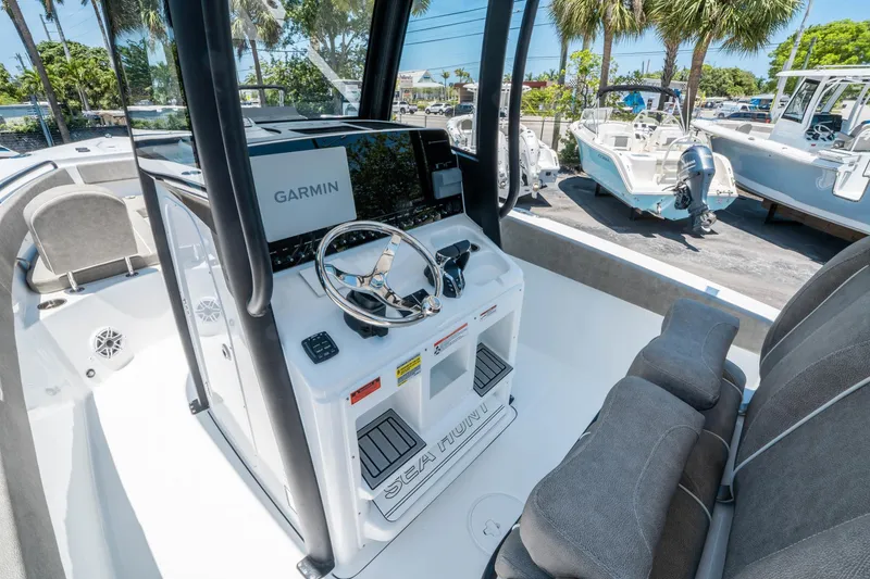 Slide: The Image of 2025 Sea Hunt Gamefish 25 boat interior with Garmin navigation system and steering wheel. - 18
