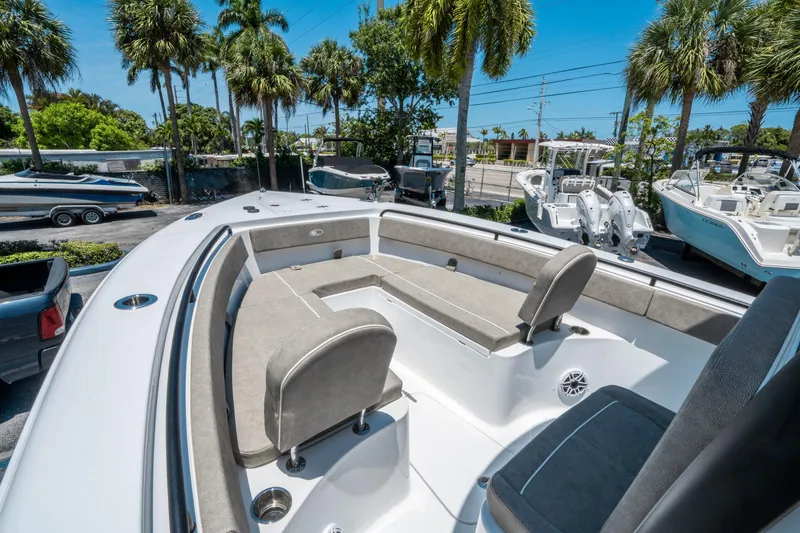 Slide: The Image of 2025 Sea Hunt Gamefish 25 boat interior with seating, surrounded by palm trees. - 24