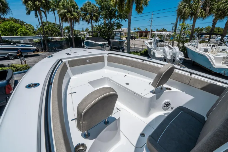 Slide: The Image of 2025 Sea Hunt Gamefish 25 boat interior with seating, surrounded by palm trees. - 27