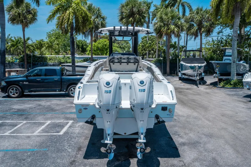 Slide: The Image of 2025 Sea Hunt Gamefish 25 boat with dual 150 engines, parked under palm trees. - 3