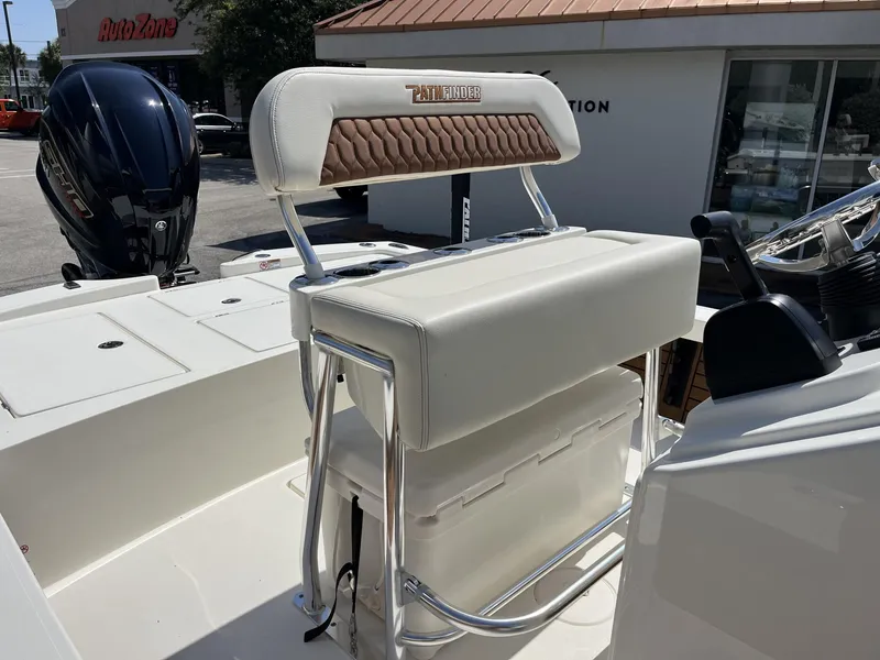 Slide: The Image of 2025 Pathfinder 2300 HPS boat interior with seating and motor, parked near AutoZone. - 16