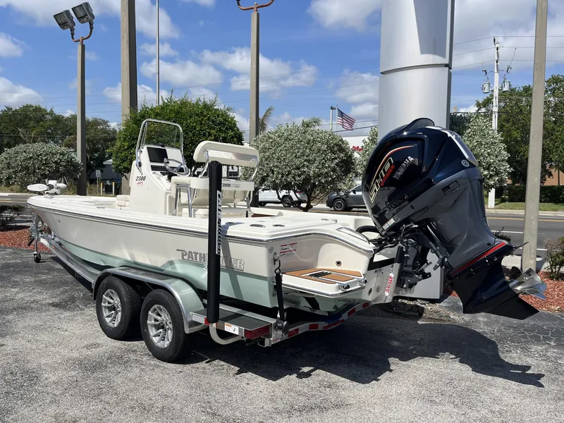 Slide: The Image of 2025 Pathfinder 2300 HPS boat on trailer with Yamaha outboard motor, parked outdoors. - 4