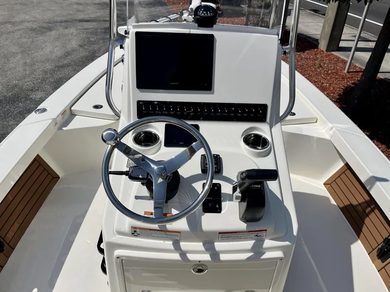 Slide: The Image of 2025 Pathfinder 2300 HPS boat console with steering wheel, controls, and navigation display. - 10