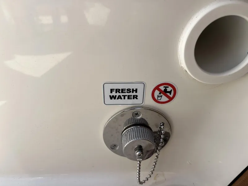 Slide: The Image of Fresh water inlet on 2025 Pathfinder 2300 HPS boat with caution sign. - 21