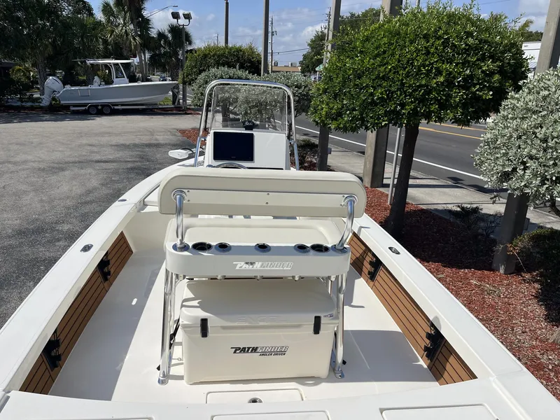 Slide: The Image of 2025 Pathfinder 2300 HPS boat with console and seating, parked outdoors. - 9