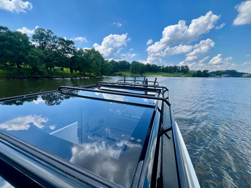 Slide: The Image of Navan C30 boat on a serene lake with clear blue skies and lush greenery. - 24
