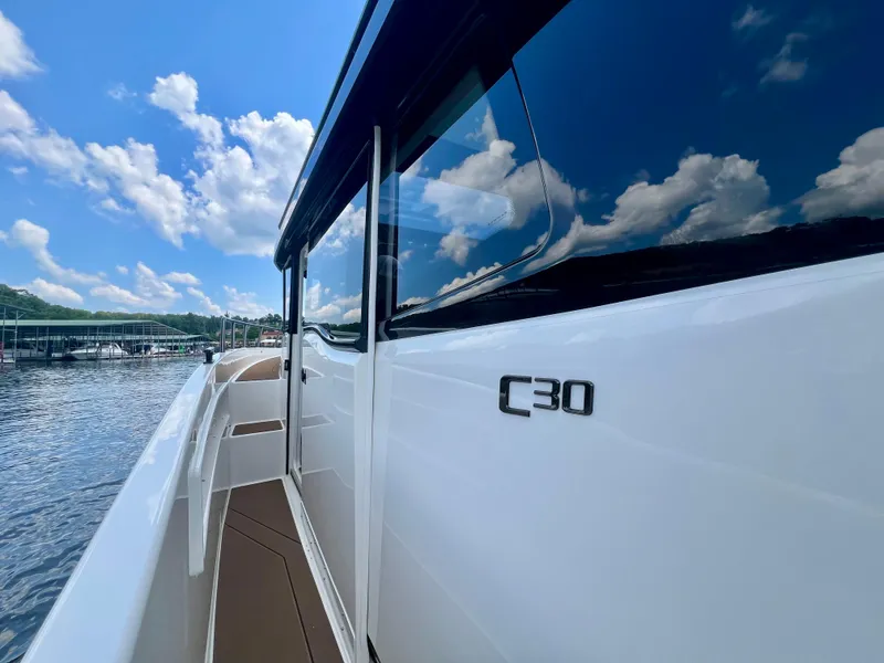 Slide: The Image of Navan C30 boat on water, reflecting blue sky and clouds, 2025 model. - 25