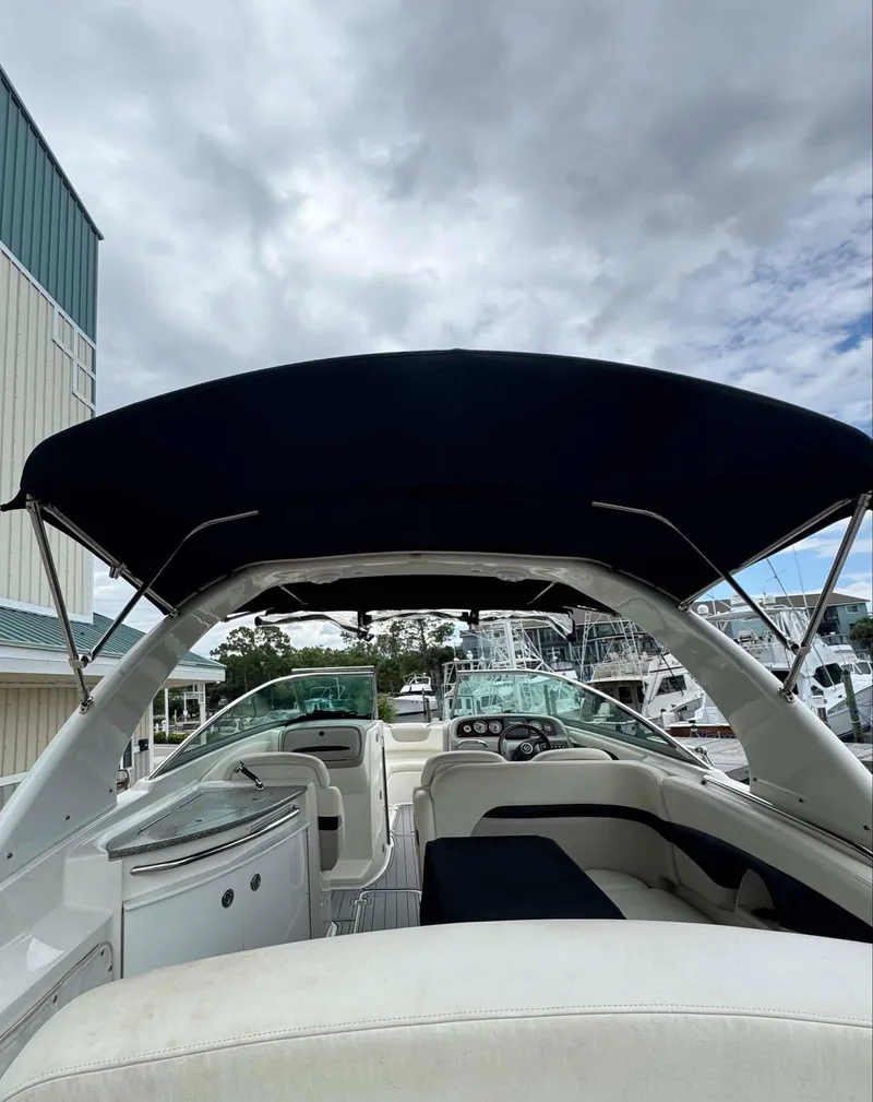 Slide: The Image of 2007 Chaparral SSX 276 boat interior with canopy, docked under cloudy skies. - 12