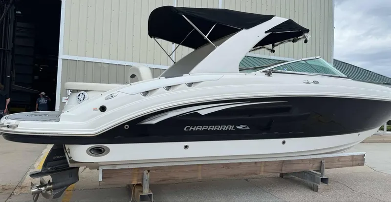 Slide: The Image of 2007 Chaparral SSX 276 boat with black and white exterior, docked on a platform. - 2