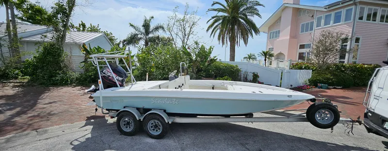 The Image of 2007 Young Boats 20 Bay on trailer, parked near tropical home with palm trees. - 0