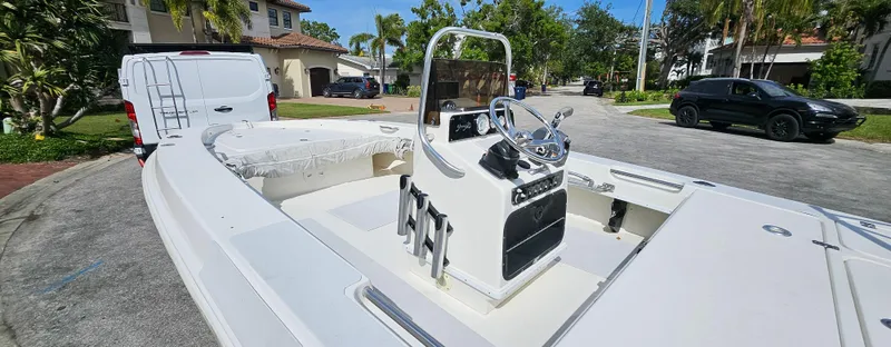 Slide: The Image of 2007 Young Boats 20 Bay in a residential driveway, showcasing its sleek design and console. - 12