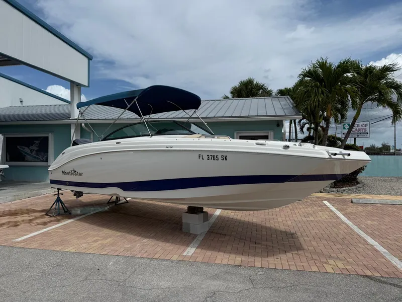 Slide: The Image of 2018 NauticStar 243DC Sport Deck boat on display in a parking lot. - 1